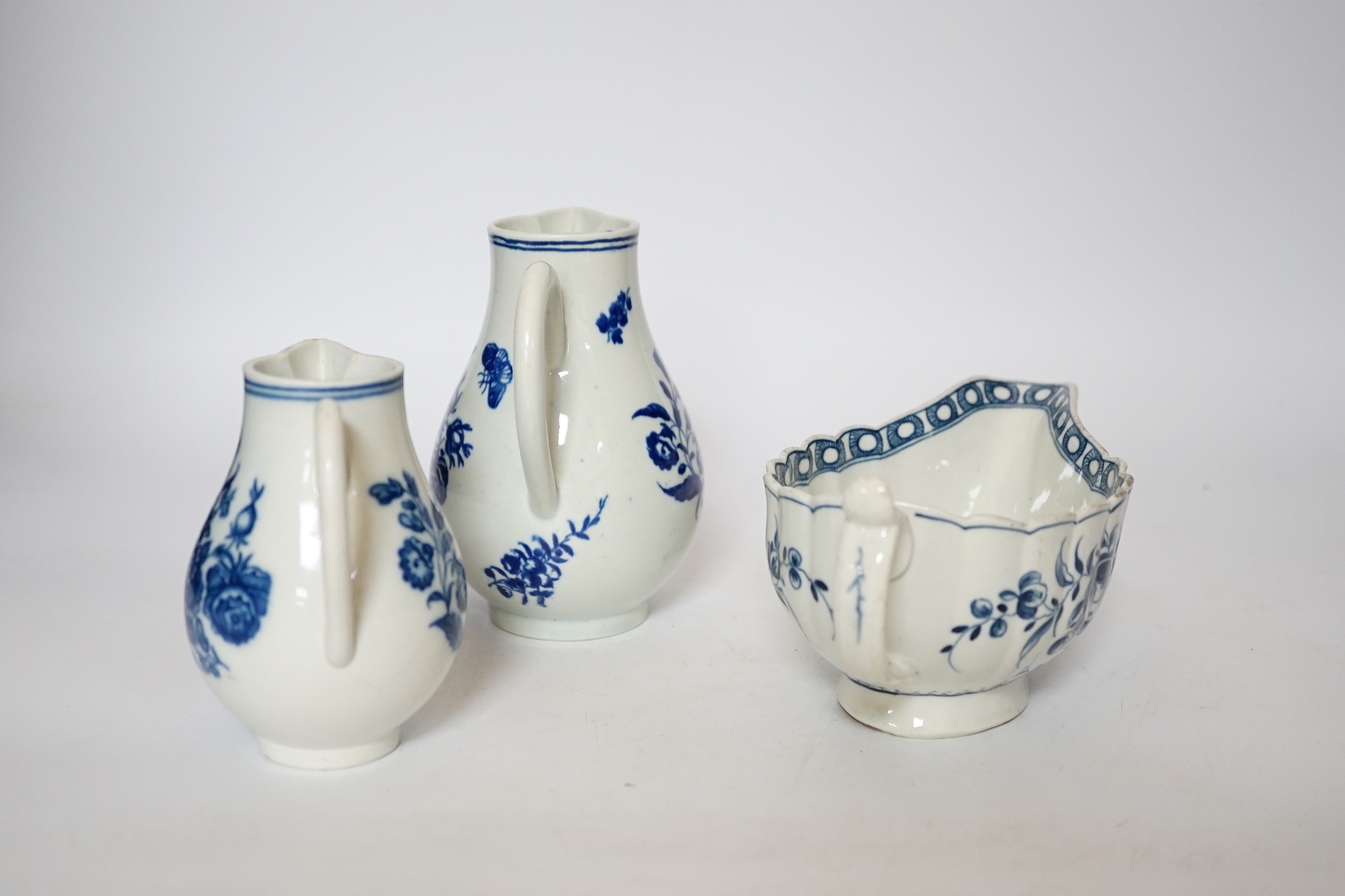 A Worcester rose pattern sauceboat c.1770 and two three flowers pattern milk jugs, largest 18cm wide
